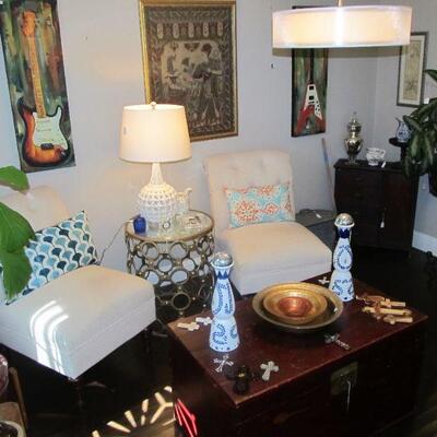 Lovely accent chairs, beautiful red trunk, decor pillows throughout & art