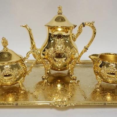 1095	WMF AMERICA 4 PIECE GOLD PLATED TEASETGODEN 49ER SERIES, TEAPOT HAS A REPAIRED FINIAL, 8 1/4 IN HIGH, TRAY IS 19 IN ACROSS THE HANDLES
