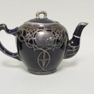 1140	3 PIECE SILVER OVERLAY PORCELAIN TEASET, LID OF THE TEAPOT HAS BEEN REPAIRED
