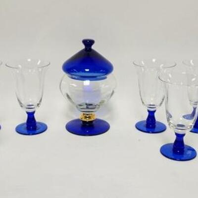 1130	20 PIECE COBALT BLUE & CLEAR GLASS, 19 GOBLETS & COVERED JAR, JAR HAS NICKS AROUND THE TOP RIM OF THE BASE, 9 1/4 IN HIGH
