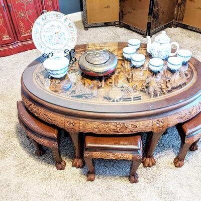 Oval shaped heavily hand carved Oriental tea table with 6 stools