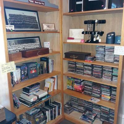 DVD's, VHS tapes, CD's, mens watches, and more. Three bookshelves.