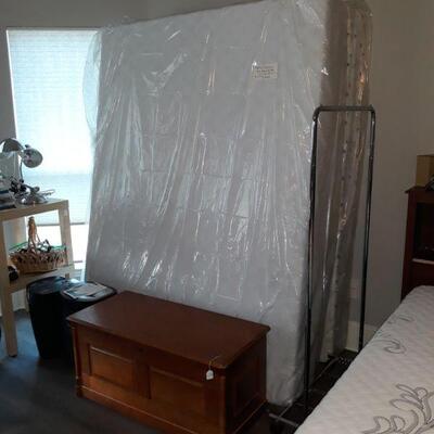 New Queen mattress set with frame, cedar chest, paper shredders, and clothing rack.