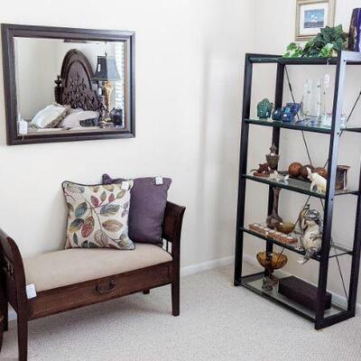 Padded storage bench with wicker sides, metal curio with glass shelves, contemporary beveled mirror