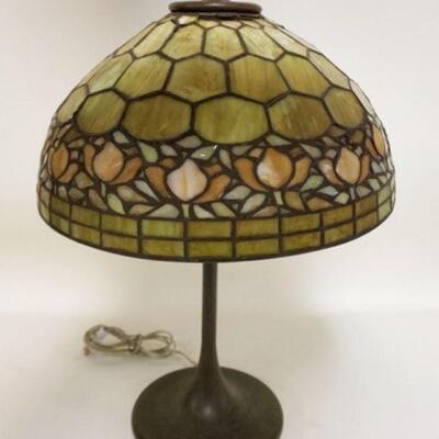 1001	ANTIQUE LEADED SLAG GLASS TABLE LAMP, HAS DAMAGE AT THE TOP OF THE SHADE CAUSING GAPS, HAS 4 OR 5 CRACKED PANELS, 23 IN HIGH X 16...