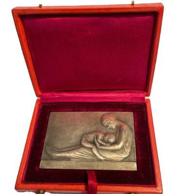 "Silver over bronze rectangular plaque in original fitted box. Raised image of woman and child. Marked â€œbronzeâ€, signed at right...