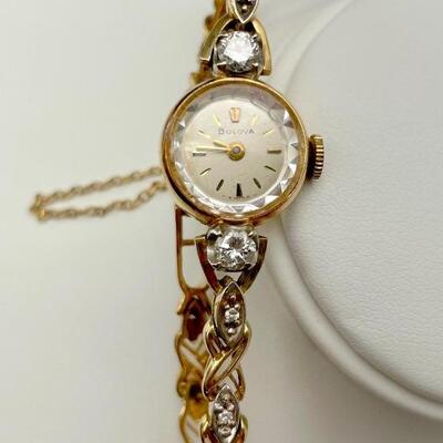 A 14kt yellow gold watch, stamped 14kt on case and band. Two prong set round brilliant cut diamonds, measuring 3.98 - 3.87 x 2.36mm...