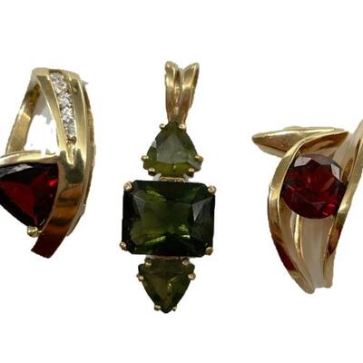 A grouping of four items including two garnet and 14kt yellow gold pendants, one 14kt yellow gold Moldovite (green) pendant, and a...