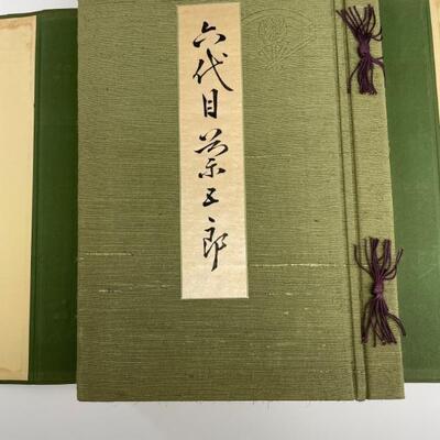 Green silk wrapped folio sized book filled with black and white Kabuki photographs, each  protected by tissue guard. Book housed in green...