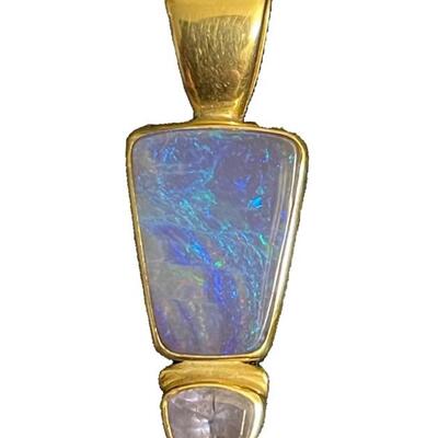 A stamped 18K yellow gold pendant, the main stone a blue and green opal, smaller stone likely tanzanite (not removed from setting). Size:...