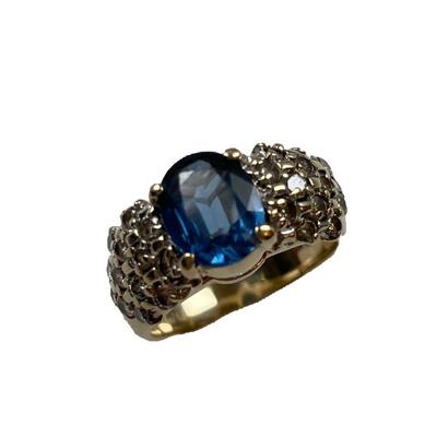 "A 14kt yellow gold, diamond and sapphire ring containing one prong set oval shape natural blue sapphire, measuring 9.00 x 7.40 x...