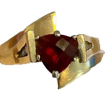 A 14kt yellow gold ring with central garnet, side panels with three diamonds each, size 9 3/4, 4.1 dwt.