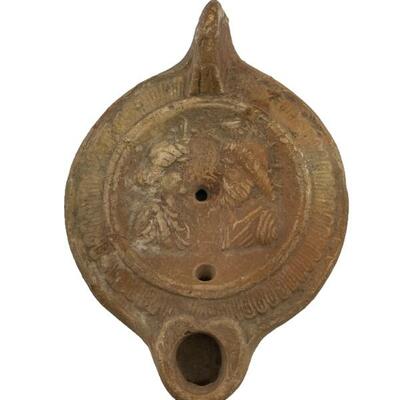 "Roman pottery oil lamp, probably circa 2nd century CE. Mold-made with a flat base, curved walls and lug handle. Central recessed...