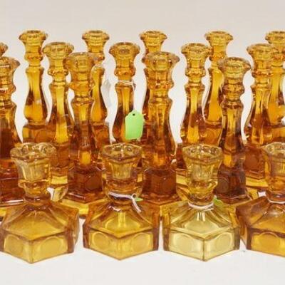1085	23 AMBER FOSTORIA COIN GLASS CANDLESTICKS, INCLUDES TWO SIZES. TALLEST 8 IN H 
