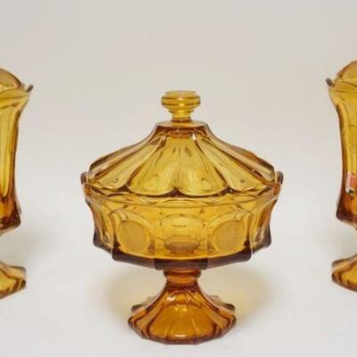 1080	3 PIECES OF AMBER FOSTORIA COIN GLASS, LOT INCLUDES TWO COVERED URNS & A COVERED COMPOTE. URNS ARE APP. 13 1/4 IN H
