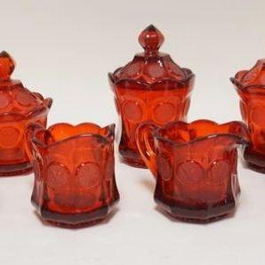 1075	9 PIECES OF RUBY RED FOSTORIA COIN GLASS, LOT INCLUDES FOUR CREAMERS, TWO SUGARS & THREE COVERED CANDY JARS. CANDY JARS ARE APP. 7...