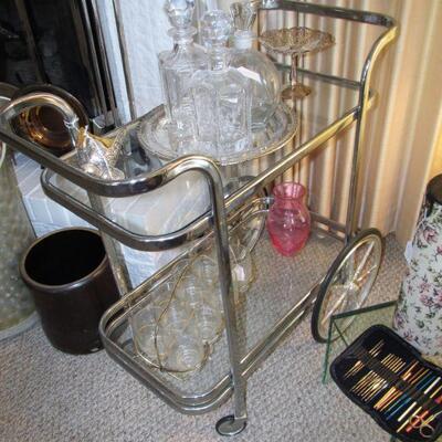 Stunning vintage mid-century chrome & glass bar cart, w/ vintage crystal decanters & silver plated accents. in the background, is...