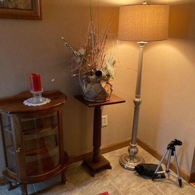 Small curved curio, plant stand, and lamp