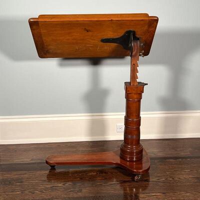 ANTIQUE WOOD EASEL | Antique easel on casters, adjustable height on a carved column; h. 45 x w. 29-1/2 x d. 16 in.