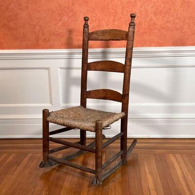 ANTIQUE ROCKING CHAIR | Ladder back with a rush seat; h. 38 x w. 17-3/4 x d. 25 in.