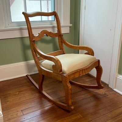 CHILD'S TIGER MAPLE ROCKING CHAIR | Highly figured tiger maple wood frame, with an upholstered cushion seat; h. 30-1/2 x w. 19 x d....