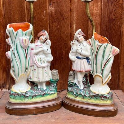 PAIR SPILL VASE LAMPS | Staffordshire spill vase figures of girls, each holding a dog, mounted as lamps on wood stands; h. 15-3/4 (over...