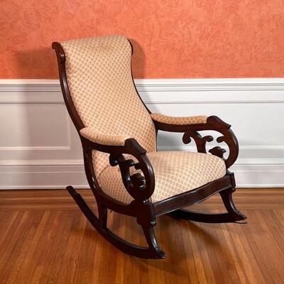 MAHOGANY ROCKING CHAIR | Antique rocking chair with a carved wood frame, upholstered seat, backrest, and arm rests; h. 39 x w. 19 x d. 37...