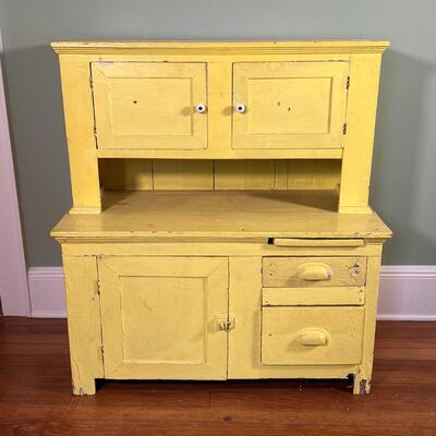 COUNTRY CHILDREN'S HUTCH | Antique primitive child's hutch with yellow paint, having two overhead cabinet doors with a lower...