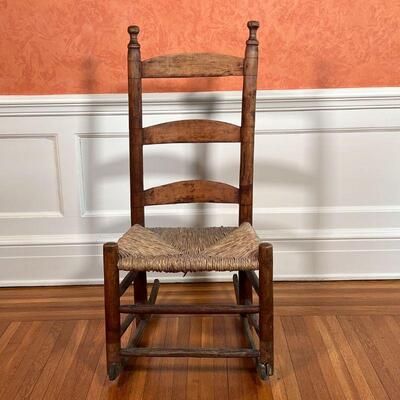 ANTIQUE ROCKING CHAIR | Ladder back with a rush seat; h. 38 x w. 17-3/4 x d. 25 in.