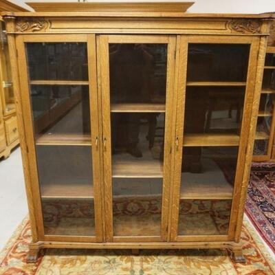 1044	OAK 3 GLASS DOOR BOOKCASE W/APPLIED CARVINGS & QUARTER COLUMN SIDES ON PAW FEET, APPROXIMATELY 56 IN X 14 IN X 60 IN HIGH
