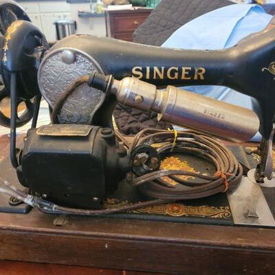 One of two, very old Singer sewing machines, this one comes in a wooden carrying case