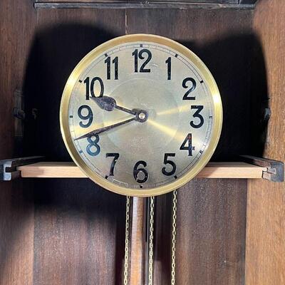 GERMAN TALL CASE CLOCK | Wood case with a beveled glass door, 8 rod chimes, brass pendulum, the face with Arabic numerals [replaced...