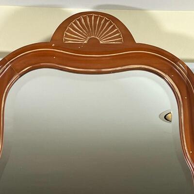 HARDEN CHERRY MIRROR | By Harden Furniture, solid cherry, beveled glass mirror in a carved wood frame with shell / linenfold motif; h. 45...