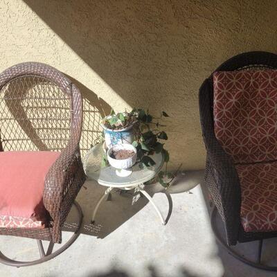 two outdoor patio chairs and a small table