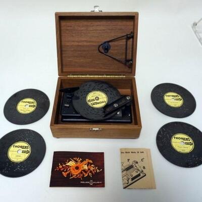 1078	THORENS REUGE MUSIC BOX WITH 4 EXTRA DISCS, IN WALNUT BOX. APPROXIMATELY 7 1/2 IN X 6 IN X 3 1/2 IN
