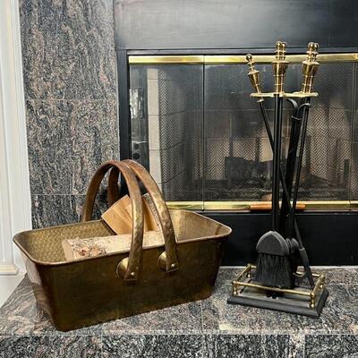 FIREPLACE EQUIPMENT | Including a set of five tools with brass handles on a fender-form stand and hammered brass basket / log holder