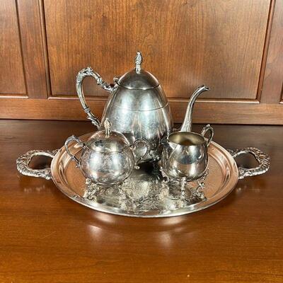 (4pc) SILVER PLATED TEA SET | A silver on copper tea set, including a teapot, covered sugar, and open creamer, all on an engraved round...