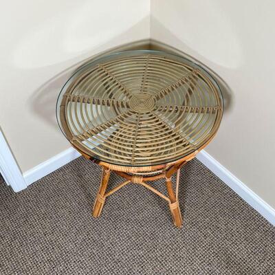 RATTAN SIDE TABLE | Rattan / cane spiral side table with a round glass top and medial shelf; dia. 24 x h. 22 in.