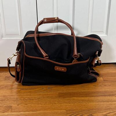 T. ANTHONY DUFFLE BAG | Black canvas with brown leather detailing, monogrammed D.M.B.; approx. 14 x 22 x 10 in.