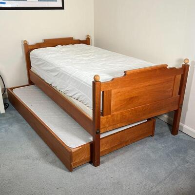 OAK TRUNDLE BED | Twin size oak bed frame of nicely figured wood with pullout trundle, two mattresses included; h. 33-1/4 x l. 79 x w. 42...