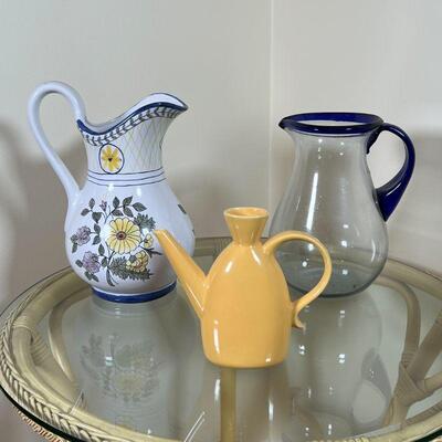 (3pc) DECORATIVE PITCHERS | Including a clear glass pitcher with cobalt glass handle and rim and a Portuguese faience pottery pitcher,...