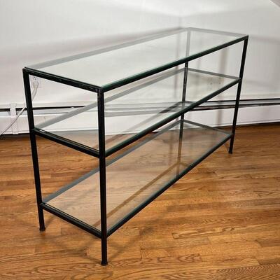 GLASS CONSOLE TABLE | Glass top with two lower glass shelves, on a black metal base; h. 33 x w. 56 x d. 17 in.