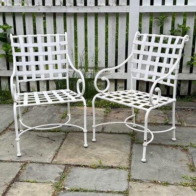 PAIR OUTDOOR ARMCHAIRS | White strap work patio dining chairs with scrolled arms and crossed demilune stretcher; h. 35-1/2 x w. 23 x d....