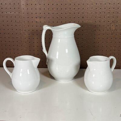 (3pc) MADDOCK & OTHER PITCHERS | Including a Maddock & Co. white ironware pitcher of large size and a pair of two white ceramic pitchers...