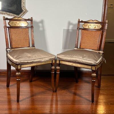 PAIR GILT CANED CHAIRS | English Regency style side chairs, carved with with gilt mirrored highlights and painted details, having caned...