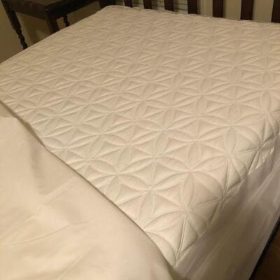 Mattress on twin beds have protective covering.