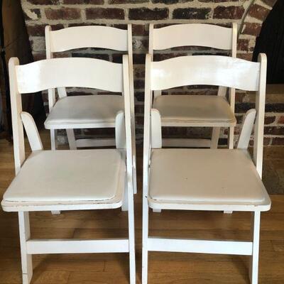 4 White Folding Chairs with Padded Vinyl Seats.