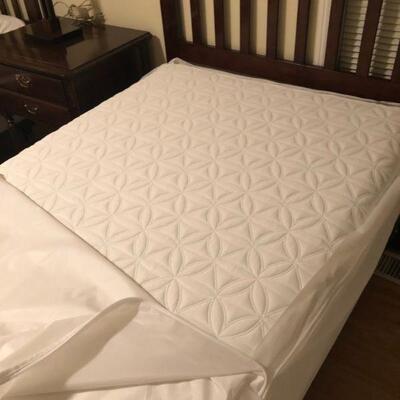 Mattress on twin beds have protective covering.