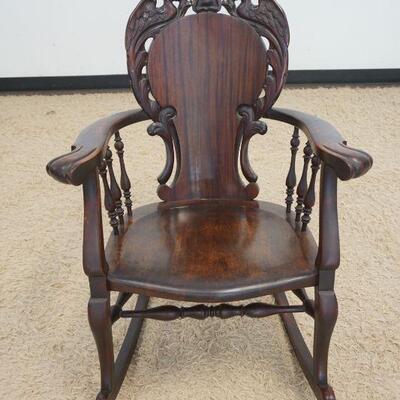 1046	CARVED ROCKER W/SERPENTS ON CREST & TURNED SPINDLE SIDES IN A MAHOGANY FINISH
