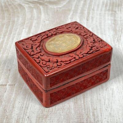 CHINESE CINNABAR BOX | Carved cinnabar with a carved stone plaque, h. 1-3/4 x 3-3/4 x 2-3/4 in.